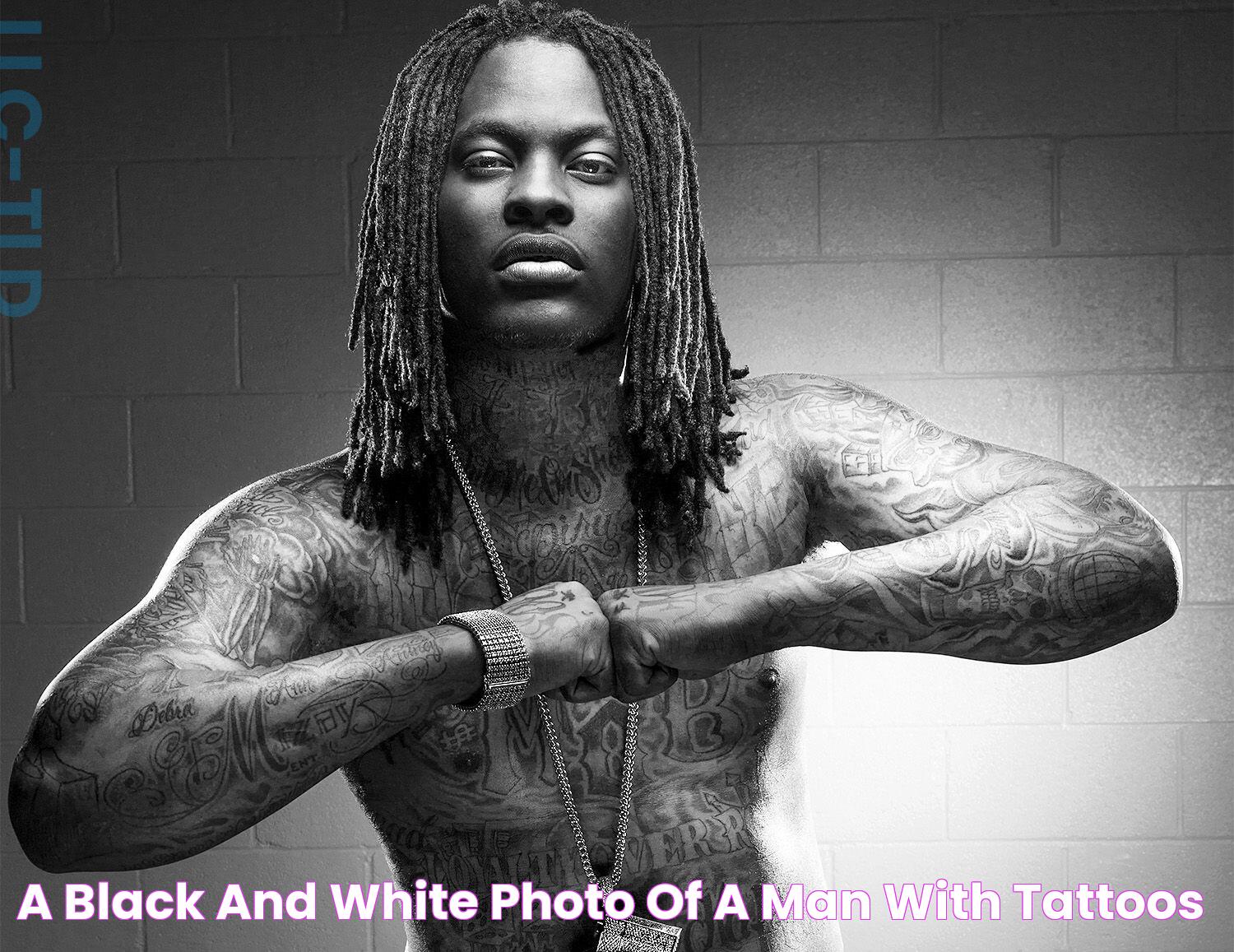 a black and white photo of a man with tattoos